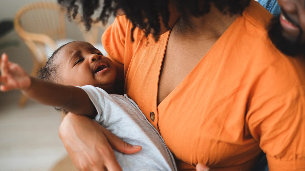 A tender moment between a mother and her baby indoors, showcasing love and closeness.